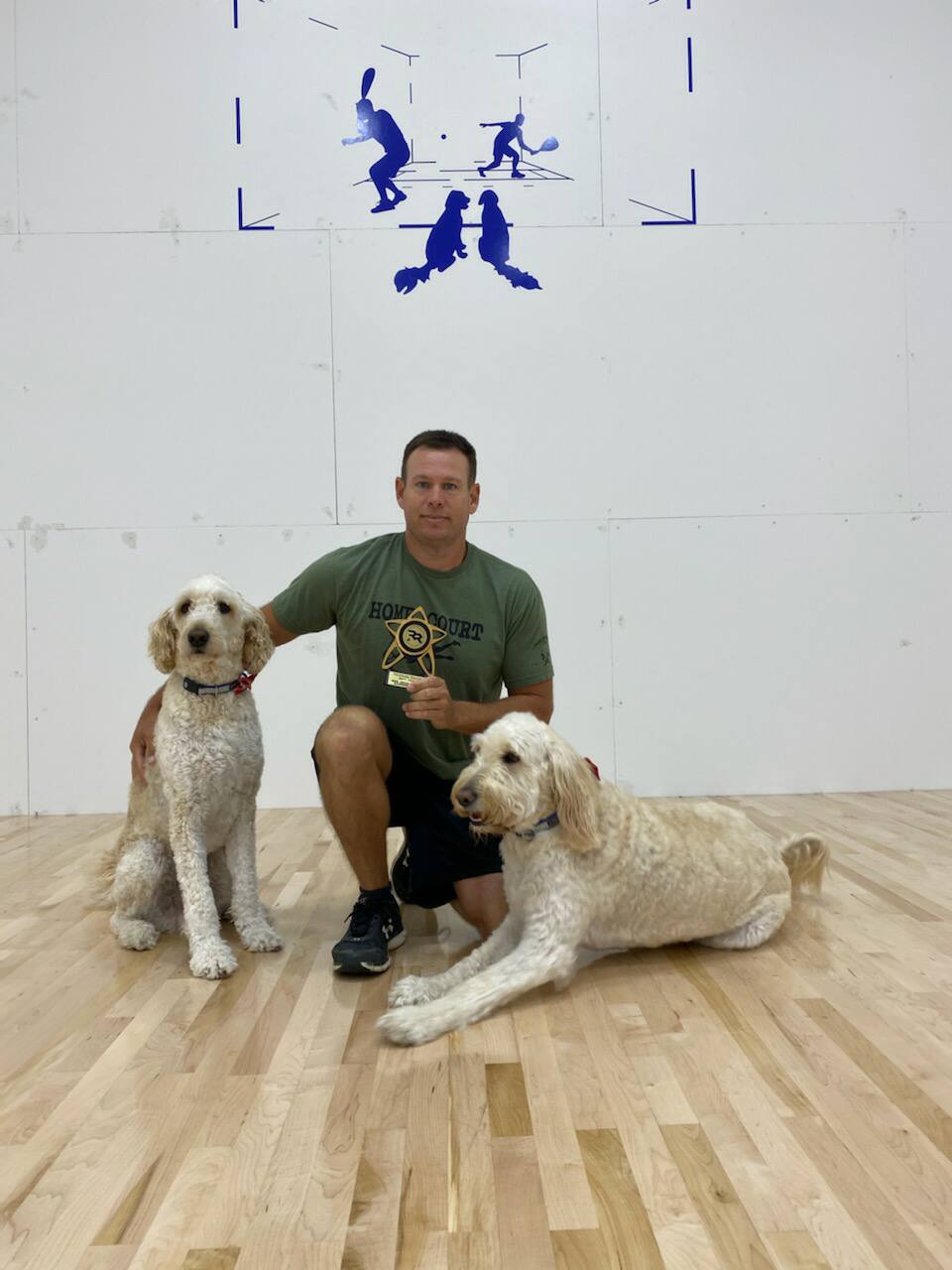 Thomas Davis with his two dogs on a racquetball court