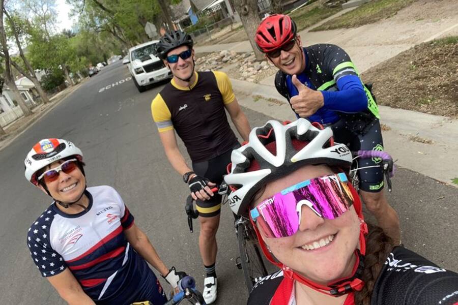 Four athletes at the 2022 Fantasy Camp pose for a photo while on a bike ride before the camp began.