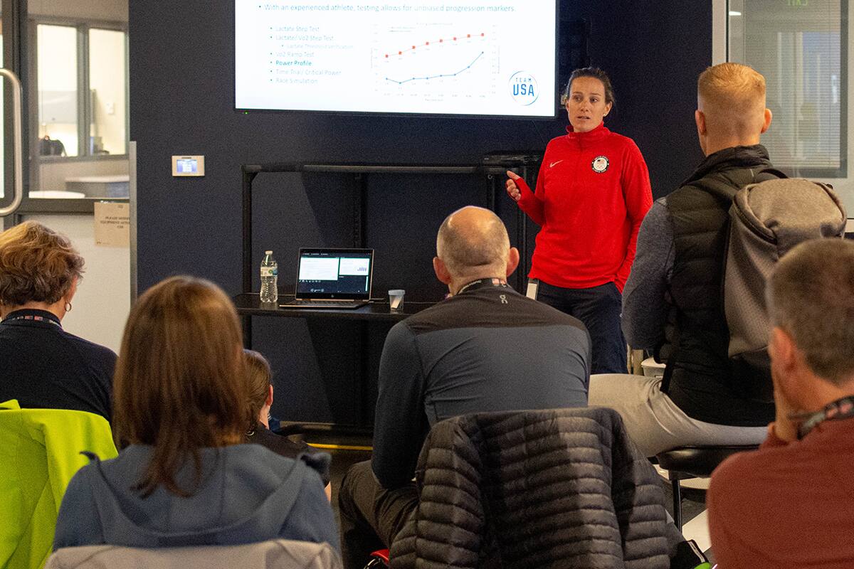 Lindsay Golich stands in front of a screen while addressing a group of coaches.