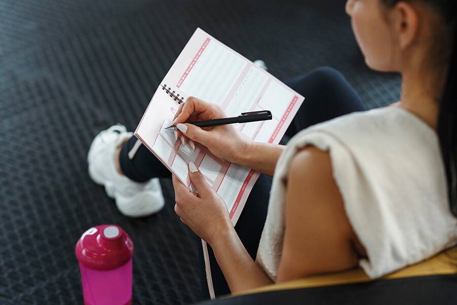 A woman writes in a daily planner or journal.