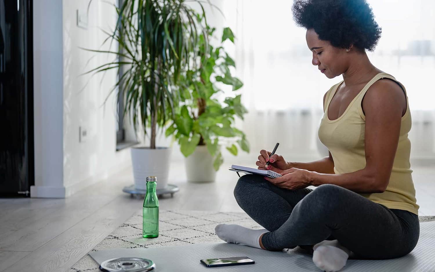 a woman writes down her fitness goals