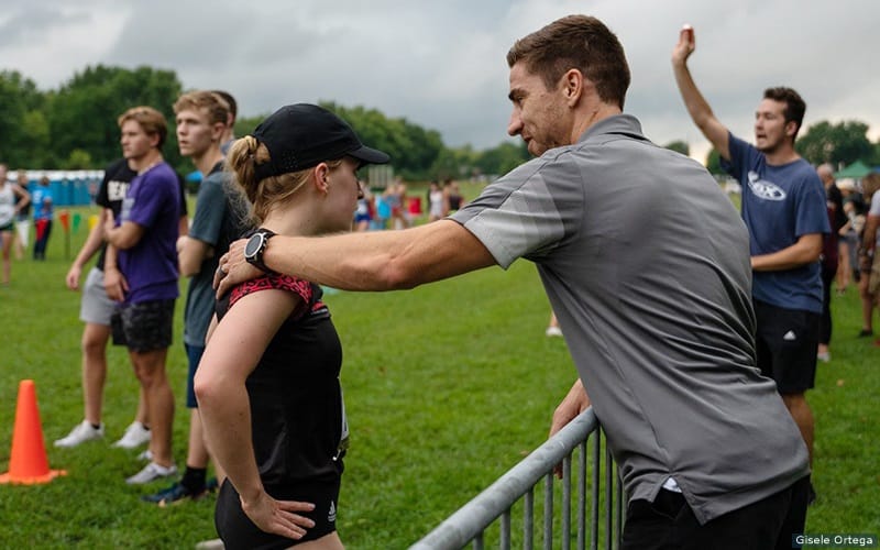 David Winton (right) consults with one of the Drury University triathletes at a race.