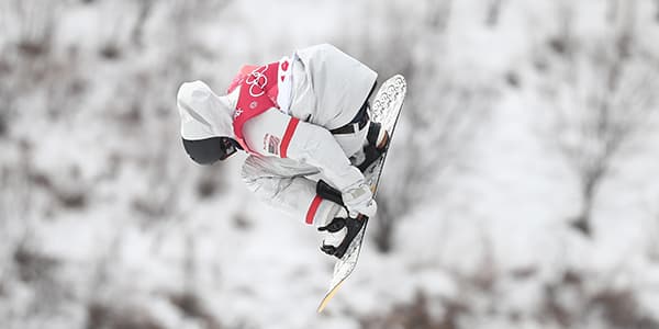 Kyle Mack competes at  PyeongChang 2018, grabbing his board as he flies through the air.