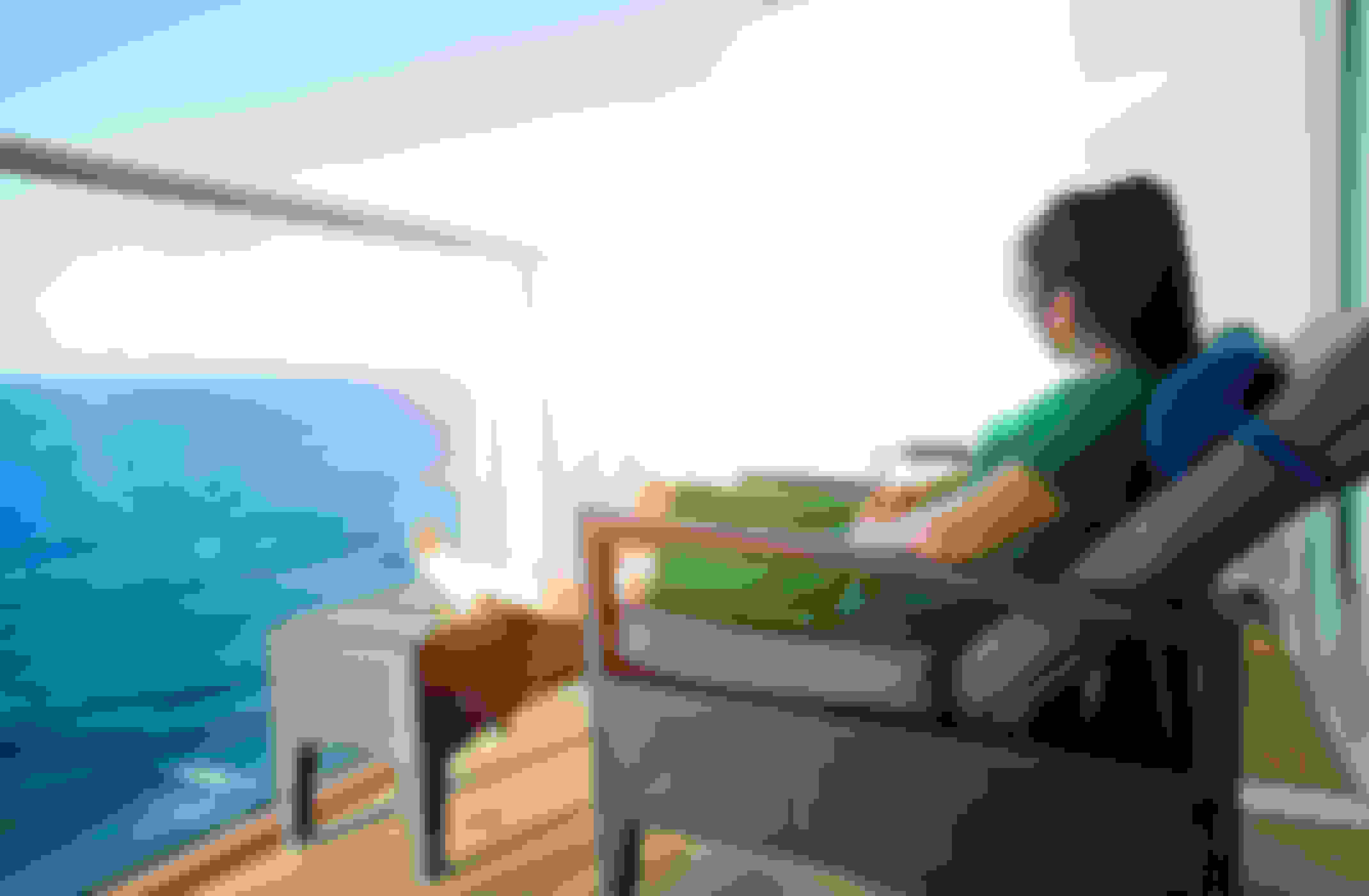 Woman relaxes on the balcony of a cruise ship suite