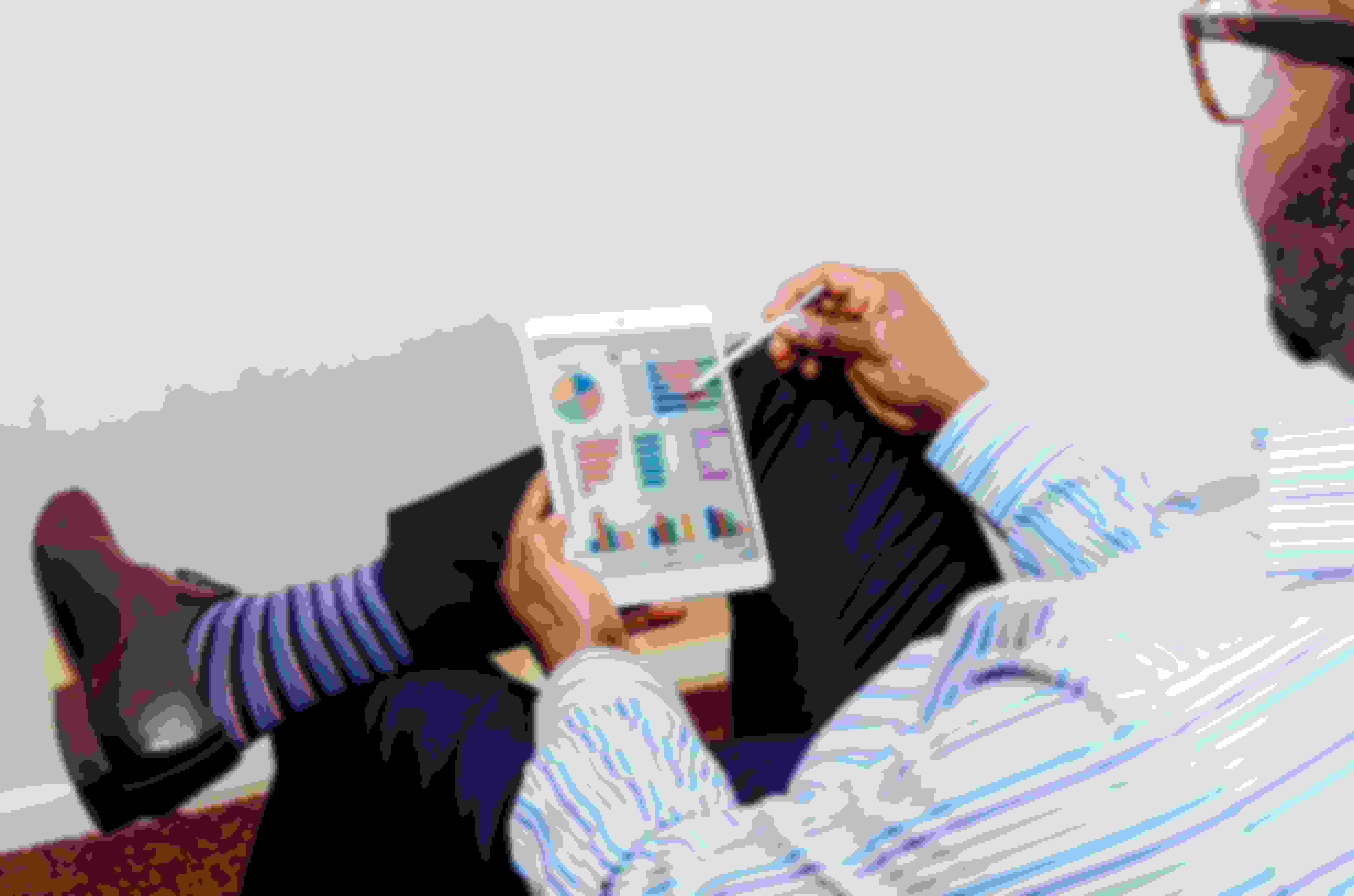 Man sitting down checking his data analytics using an iPad