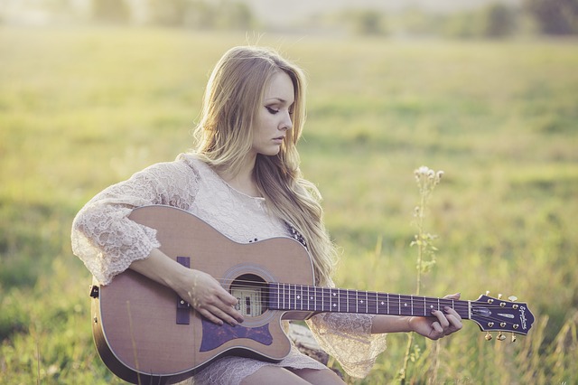 Musicoterapia: Mulher tocando violão para relaxar.