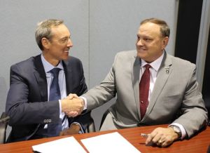 Robert Nioa (L) shakes hands with Colt senior vice president (Govt and military programs) Kenneth Juergens. Credit: NIOA