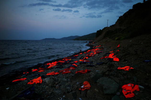 GREECE, Lesbos Island : This photo taken on September 8, 2015 on the Greek island of Lesbos shows life vests left on the shore by incoming refugees. Overwhelmed by the 20,000 refugees and migrants currently camped on the holiday island, authorities hastily set up a refugee registration centre September 8 on a parched old football pitch. Local authorities have found it impossible to keep up with the pace of the influx, and tensions have boiled over. AFP PHOTO/Angelos Tzortzinis