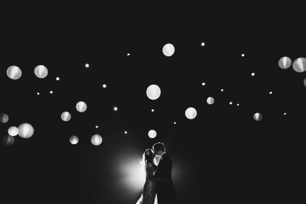 A bride and groom kiss for an artistic night portrait. Summer, 2014. © Ross Harvey.