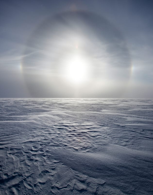 A sun dog on the Greenland ice sheet. Sun dogs are optical halos that are visible around the sun from the ice crystals in the air, 2010. © Sebastian Copeland.