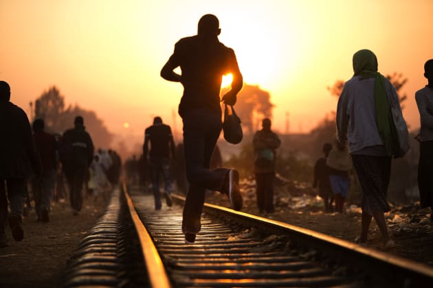 A man rushes along the tracks during the morning commute. Many Kiberans go to jobs at a nearby factory that pays about a $1 a day. © Deanne Fitzmaurice.