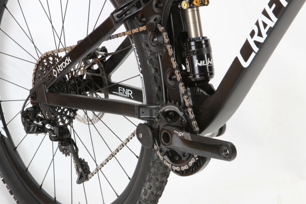 Certainly a lot going on around the ENR’s drivetrain. The idler is actually mounted to a moving suspension component and the lower guide is required to maintain sufficient chain engagement.