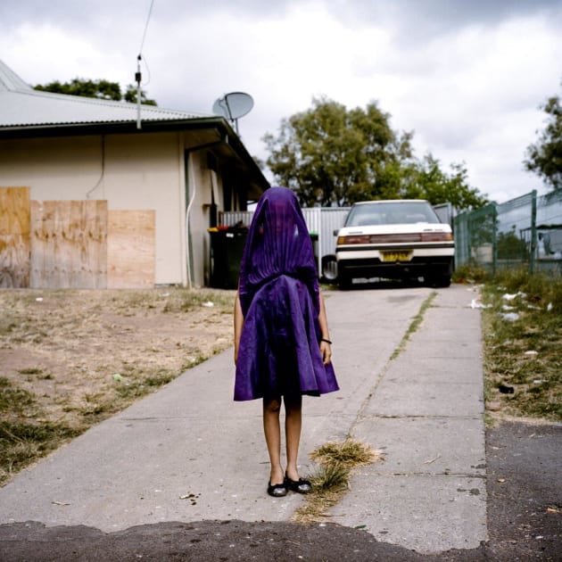 Laurinda, a young Kamilaroi girl, plays with her dress as she waits for the bus that will take her to Sunday school. © Raphaela Rosella (Oculi).