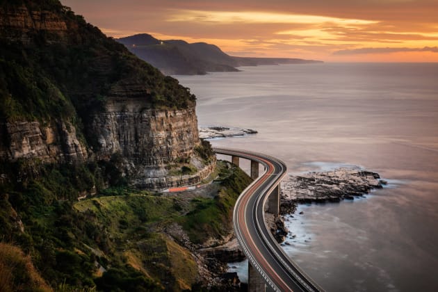 Sea Cliff Bridge, Illawarra, NSW. I had seen this incredible view several times but was really hoping to photograph it with some sky colour. After a very early start I was really excited when the sky lit up as my effort was rewarded. I chose a tighter focal length to focus onto the part of the bridge that turned around the corner. With my long exposure came a car on the bridge, and some great traffic trails as a result. Sony A7R, Canon 24-105mm f/4 @ 55mm, 22 sec at f/11, ISO 100, tripod