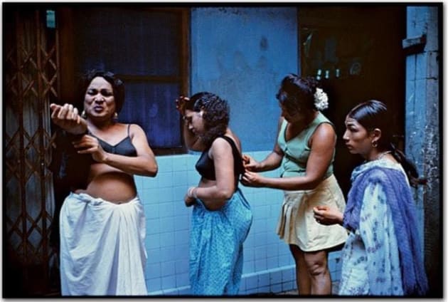 The original image by Mary Ellen Mark. She spent three months befriending the prostitutes who worked on a single long street in Bombay for her series in 1978.