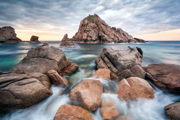 Sugarloaf Rock, South Western Australia. When I arrived at this location I noticed that the seas were quite a lot calmer than on previous visits. I made my way down to the rocky shoreline and noticed the water flowing over the rocks, which I then used as the foreground of my composition. Canon 5D Mark III, Canon 17-40 f/4L, 2 sec @ f/8, tripod