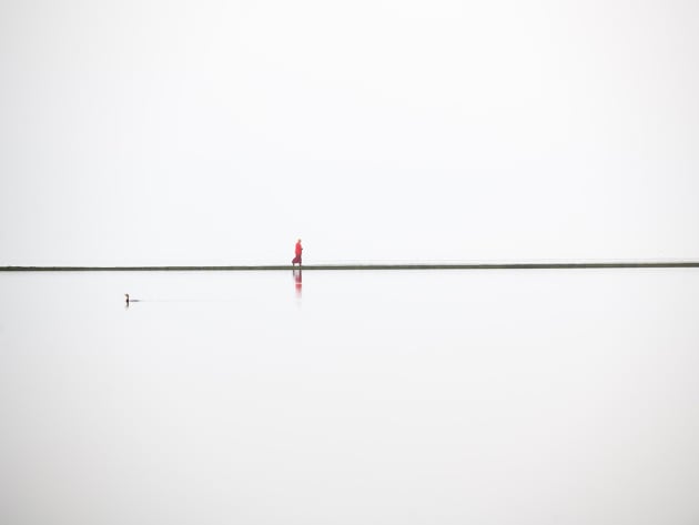 © Craig Easton, UK. 
Winner, Land, Sea, Sky portfolio.
West Kirby, Wirral, UK. A lone Buddhist monk walks around
the boundary wall of the West Kirby Marine Lake.