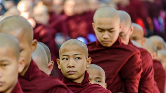 Young Monk rolling his eyes at tourists by Arjan Paauw