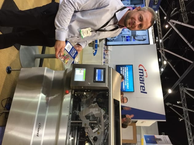 The company was showcasing its new M360, a linerless wraparound labeller that has just been launched in Australia. The label comes with glue strips and a silicone band so it requires no backing paper, reducing waste and allowing more labels per reel.
The packaged meat tray product runs through a weighing unit, according to David Lynch, who was on the stand. This calculates the product weight, and the M360 prints on to the label, cuts the label and applies it to a tray. The label can wrap all the way around the tray or in a C-wrap, just around the top and sides. The machine does 90 trays per minute and can be adjusted for different-sized products in just a few seconds. The label allows more space for product information so brands can make a bigger splash on the retail shelf.