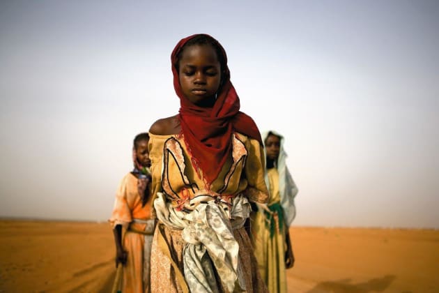 Young girls leave an IDP camp to gather firewood for their families. For some, the work will take over seven hours and lead them past government checkpoints and leave them exposed to attacks. Darfur, Sudan, 2005. © Ron Haviv/VII Photo.