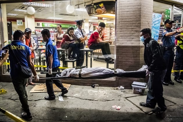 Funeral parlor workers carry away the body of Edwin Mendoza Alon-Alon (36) who was killed by an unknown gunman on the road in front of a 7-Eleven store in Manila, Philippines. Photo © Daniel Berehulak, Australia, for the New York Times, First Prize, News Stories.