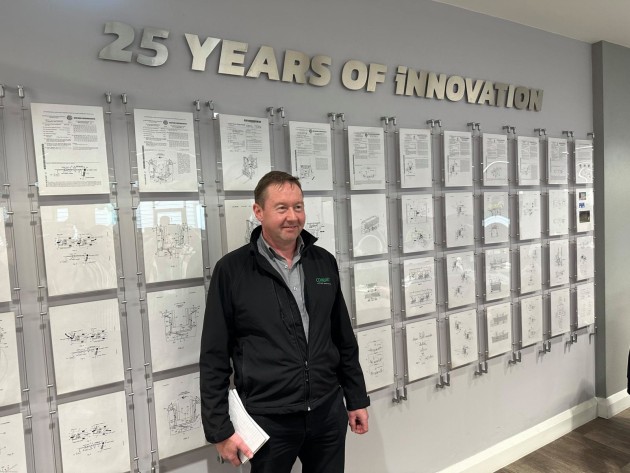 Combilift’s first employee, Mark White, standing with some of the company’s 140 patents. 