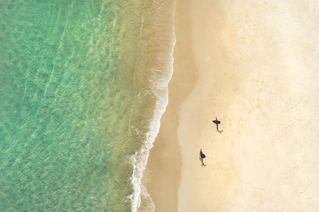 © Craig Parry. Surfers’ Shadows. An abstract image of two surfers as their shadows run symmetrical across the sand in Byron Bay. A finalist in 2013 Nikon surf photography competition held in conjunction with Surfing Australia.