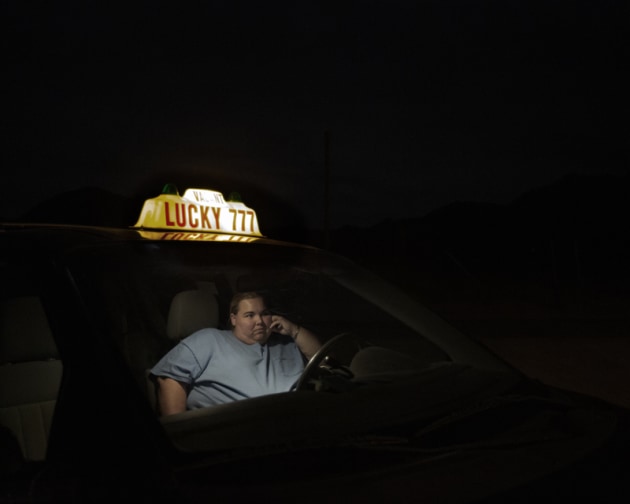 © Juliet Taylor. 1st Place - Portrait Prize. Unlcky. Pioneertown sits in the basin of the San Bernardino High Desert,
where is is so black at night you can barely see a foot in front of
you. Sheryl sits in her taxi outside Pappy & Harriet's bar, waiting
for her husband to finish drinking so she can take him home.