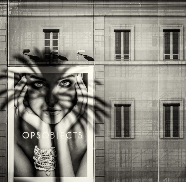 © Judi Thies. In The Shadow of a Palm Tree. "A poster girl, overshadowed by a palm tree from across the road, and supported by temporary scaffolding. Trapped in an urban environment, we sometimes long for a new and exciting environment. It can be a great distance from where we are, yet such a short distance to travel to in our imagination."