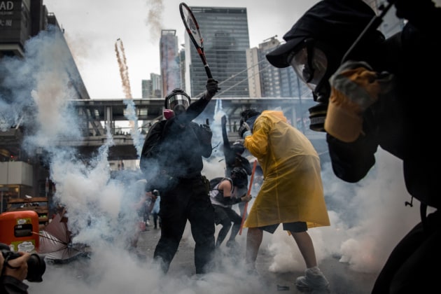 © Chris McGrath. HONG KONG - AUGUST 25: A protester uses a tennis racquet to hit back tear gas canisters during clashes with police after an anti-government rally in Tsuen Wan district on August 25, 2019 in Hong Kong, China. Pro-democracy protesters have continued rallies on the streets of Hong Kong against a controversial extradition bill since 9 June as the city plunged into crisis after waves of demonstrations and several violent clashes. Hong Kong's Chief Executive Carrie Lam apologized for introducing the bill and declared it 