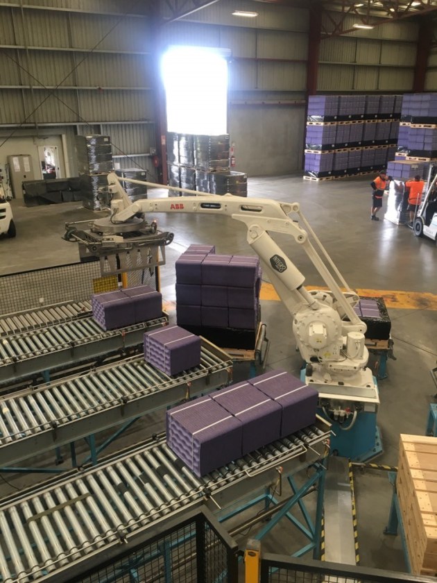 Robot about to lift bundle off conveyor to stack on the waiting pallet. (Image: SMC)
