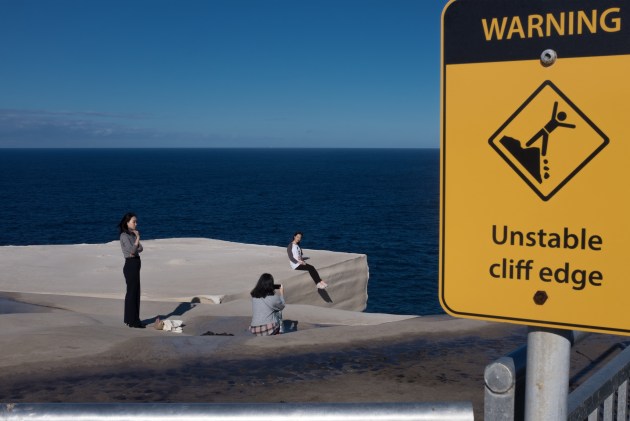 Wedding Cake Rock – hundreds of people a year illegally climb over the fence to take a selfie on a rock that has a high possibility of collapsing 30 meters into the sea. Image: Tim Levy