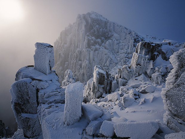 The calendar cover image for 2014. It shows dolerite columns and boulders looming out of the mist at Mt Field National Park in Tasmania. The image is by Grant Dixon.