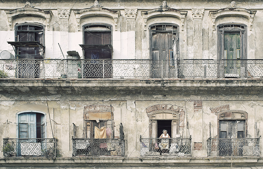 Photo of a lady standing on a balcony in Old Havana.