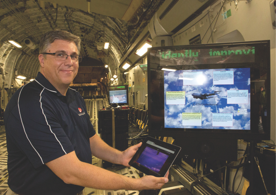 Todd Stibor, from L3 Mission Integration, demonstrates the new wireless capability being brought to the C-17A Globemaster by wirelessly connecting up a Tablet. Credit: Defence