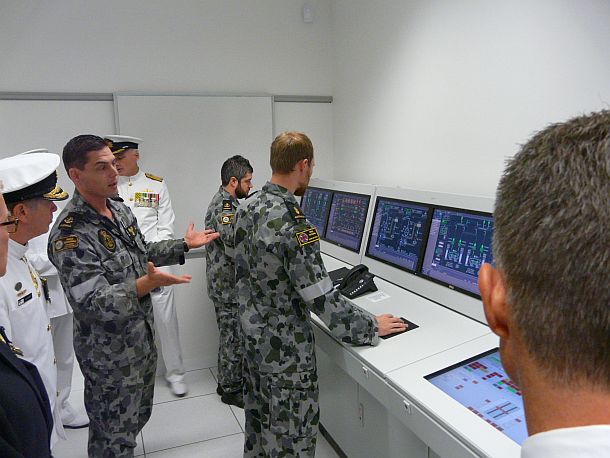 LSMTP Cook explain to the gathered dignitaries, inlcuding VADM Barrett (Left) the functions of one of the engineering simulators at the NTSC. Credit: ADM (Patrick Durrant)