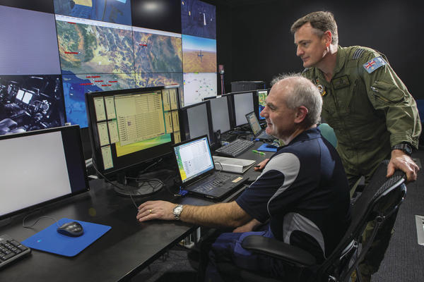 Mr Daryl Hopton from CAE Australia and Commanding Officer No 285 Squadron, Wing Commander Jason Baldock watch the progress of the training in the C-130J Simulator during Exercise Coalition Virtual Flag 16. Credit: Defence