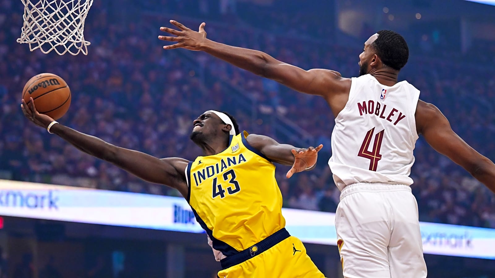 Pascal Siakam in flight to the basket with his right arm outstretched with the ball in hand against Cleveland Cavaliers forward Evan Mobley