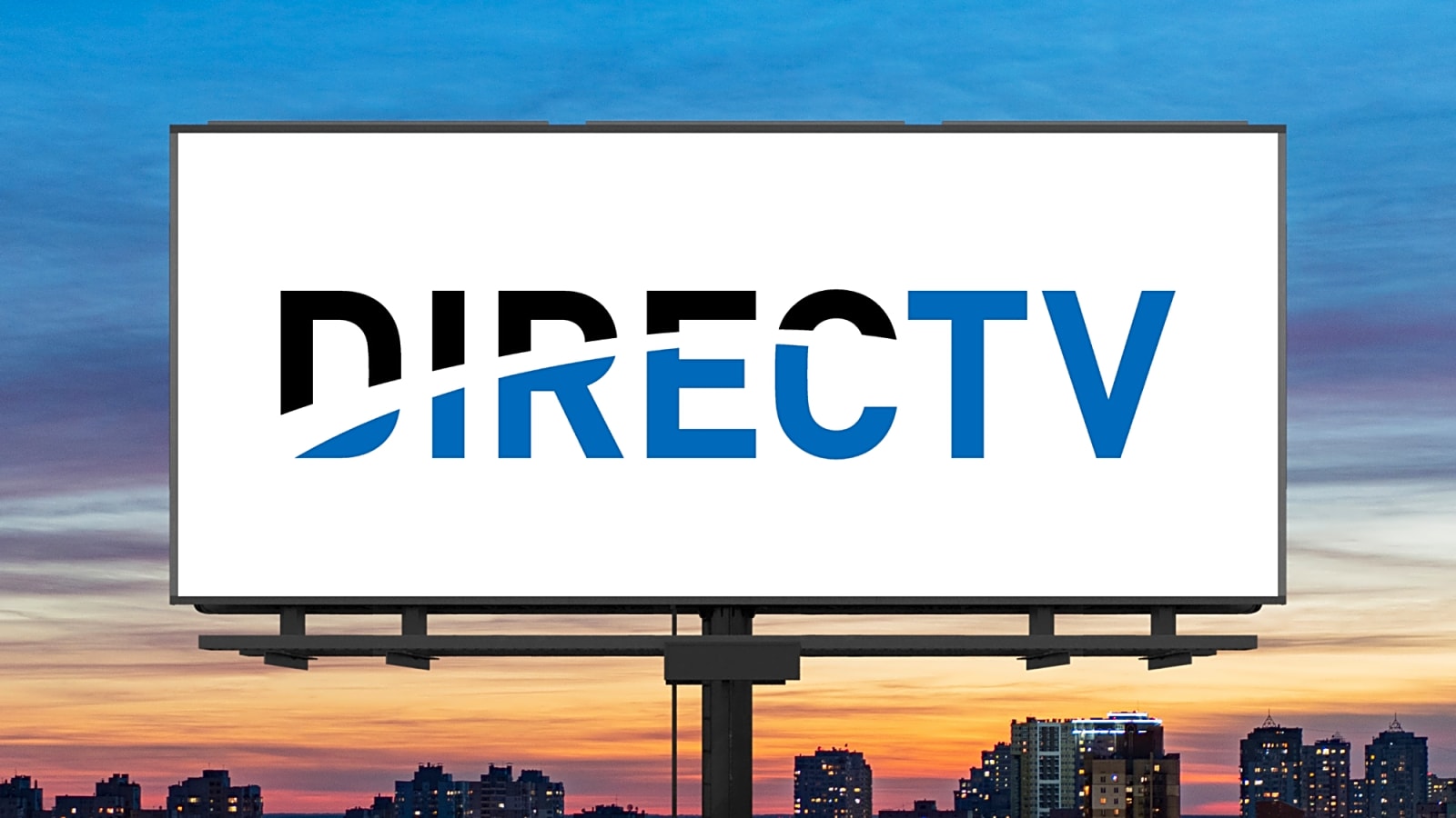 DIRECTV Logo On A White Billboard Against A City Backdrop At Dusk