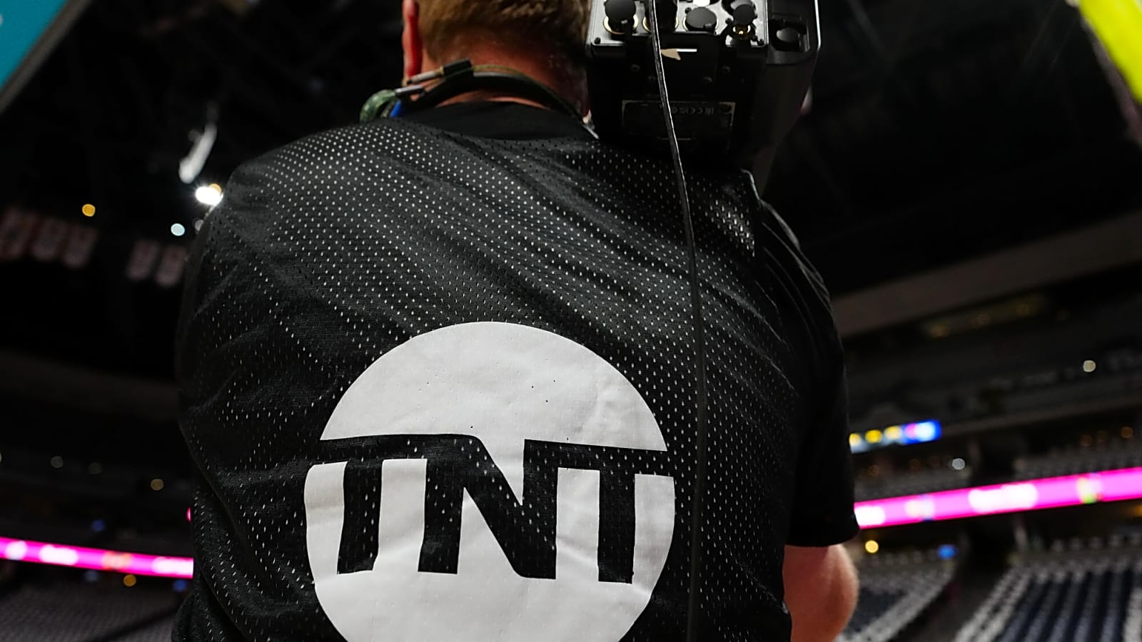 TNT baseline camera operator with the TNT logo on backside of shirt.