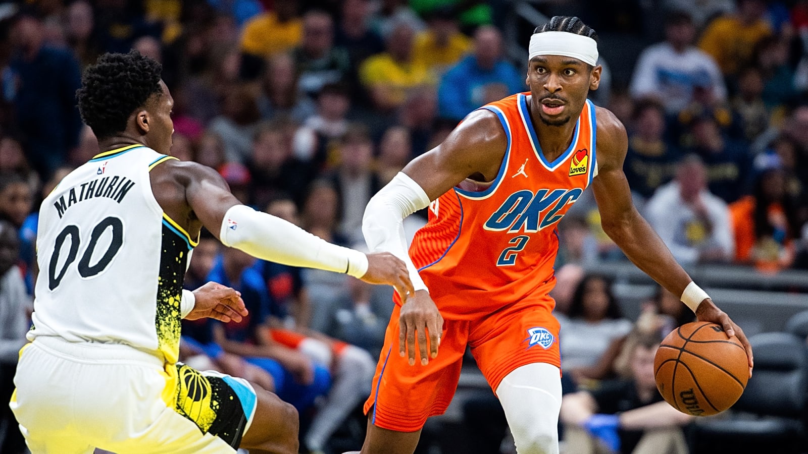 Shai Gilgeous-Alexander (2) dribbles the ball in his left hand while Indiana Pacers guard Bennedict Mathurin (00) defends and shifts to his right