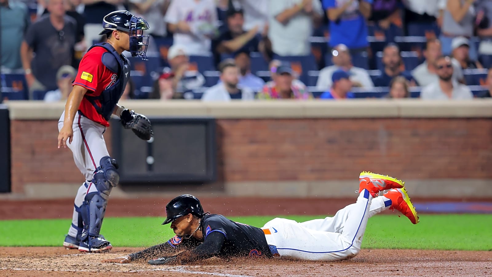 Mets shortstop Francisco Lindor dives for a score in front of Atlanta Braves catcher Drake Baldwin