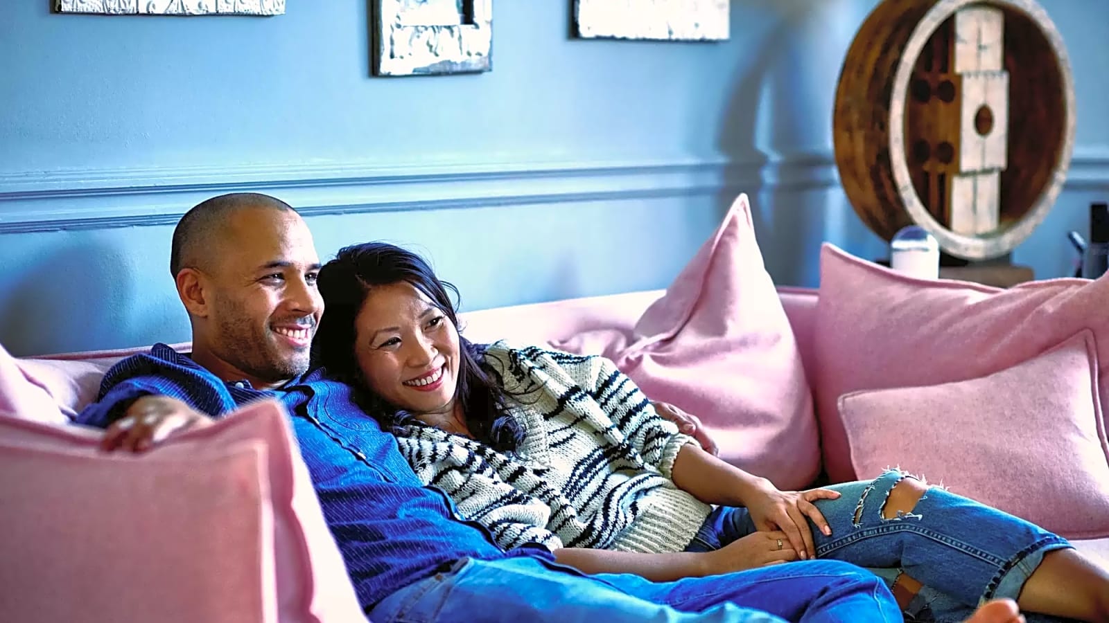 Couple watching tv on a couch in living room