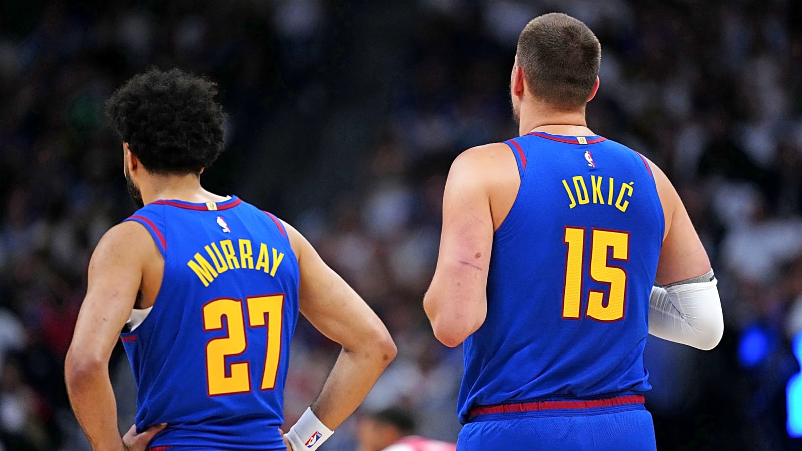 Jamal Murray and Nikola Jokic stand side by side with their backs to the camera, displaying their last name and jersey number