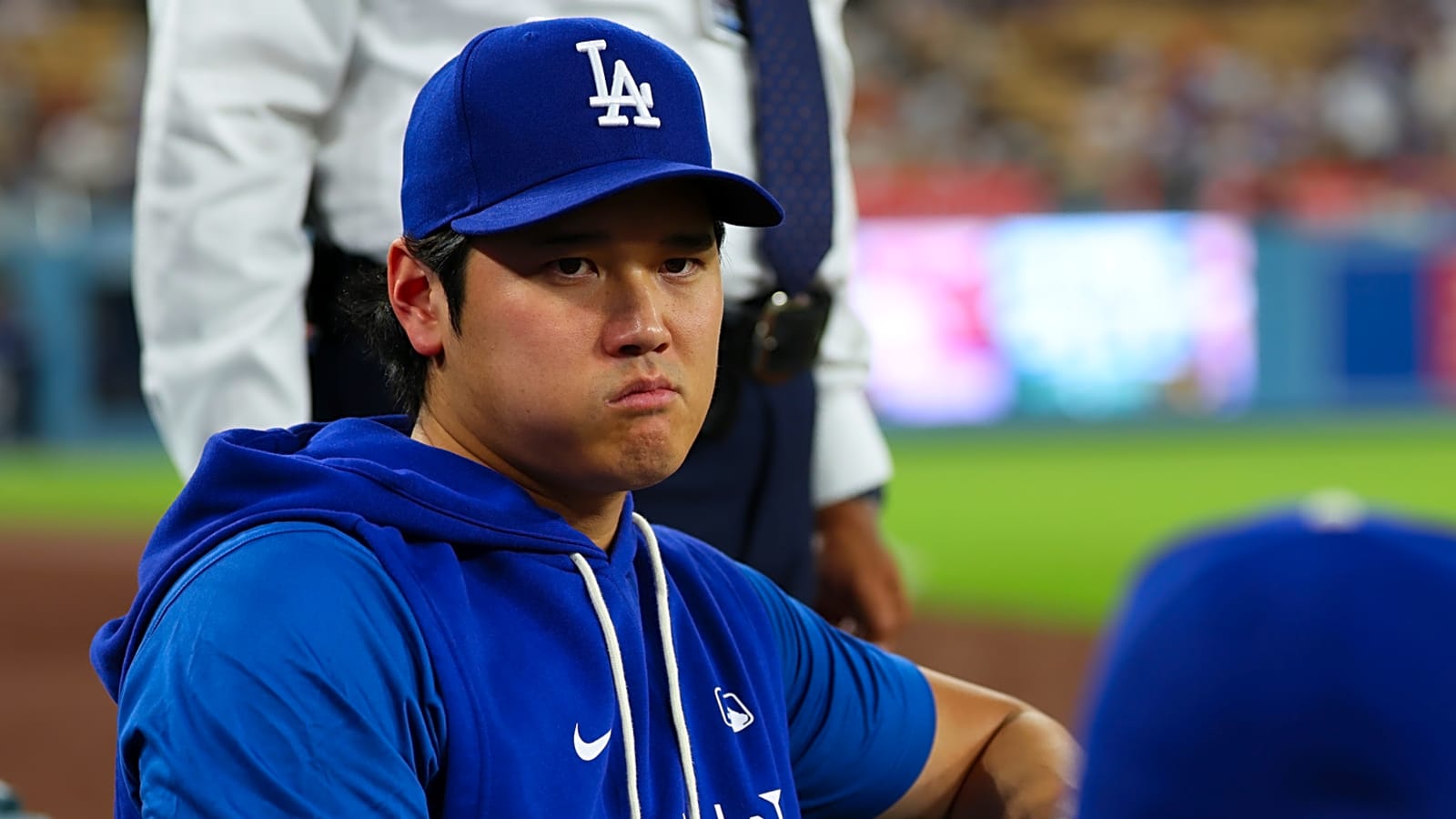 Shohei Ohtani sitting in the dugout reflecting on the MLB Injury Report details