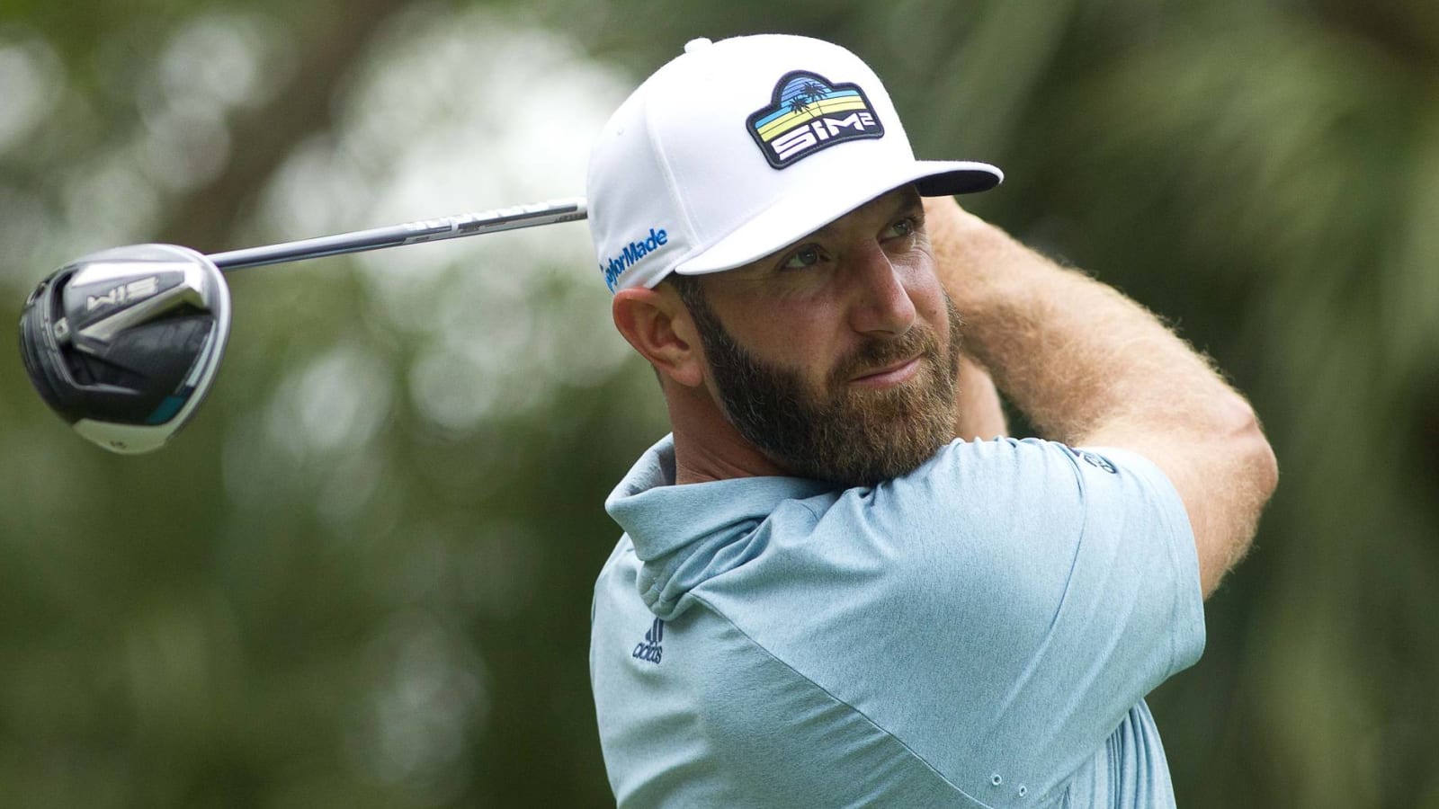 Dustin Johnson drives ball over green on a par-4