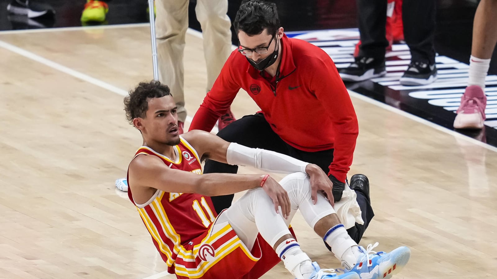 Watch: Trae Young twists ankle stepping on referee Sean Wright’s foot