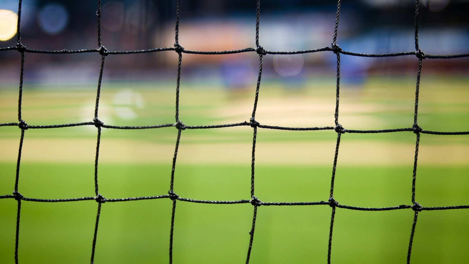 Close-up of a soccer net with a blurred field behind