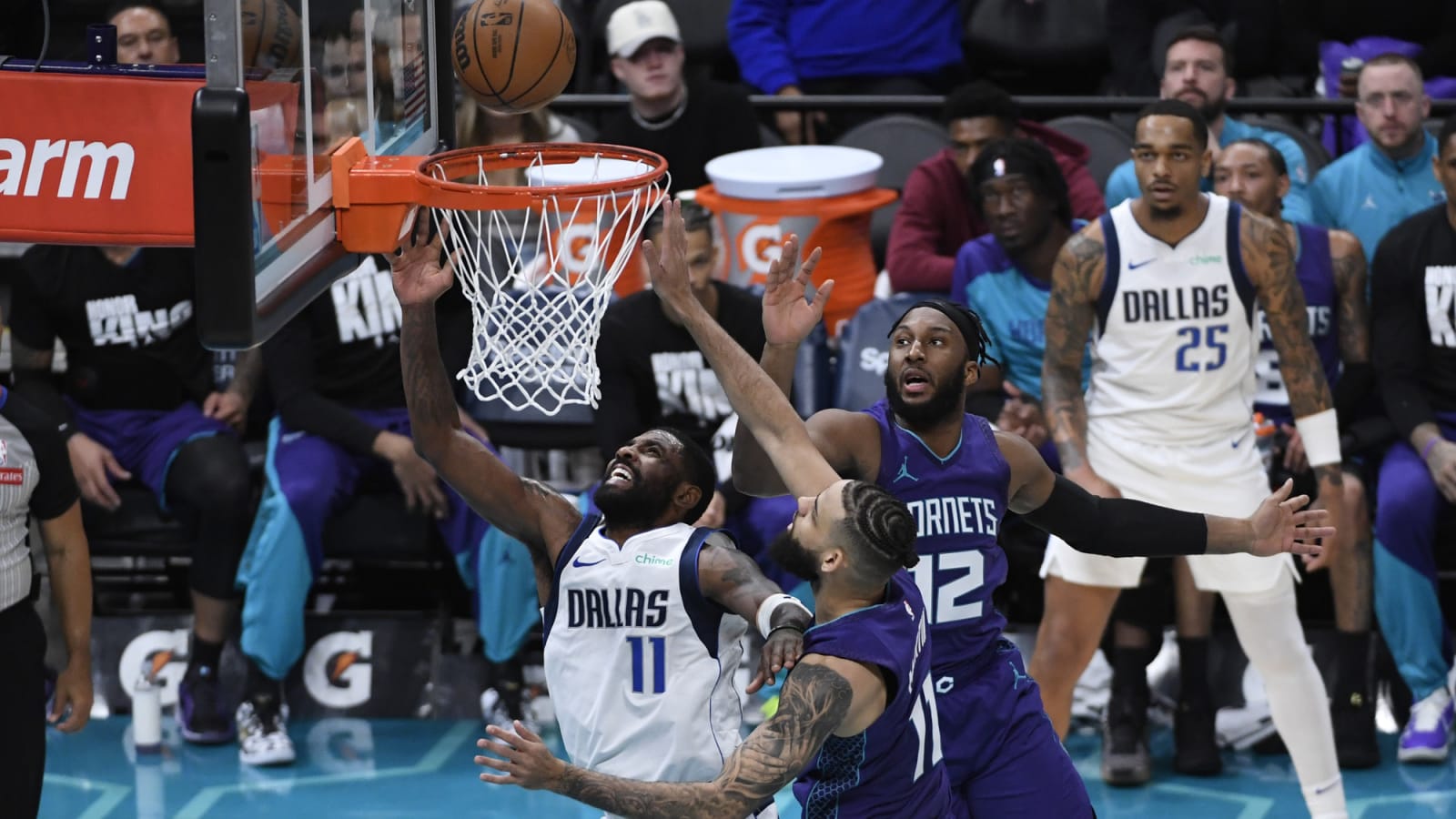 Kyrie Irving drives past Hornets guards at Spectrum Center