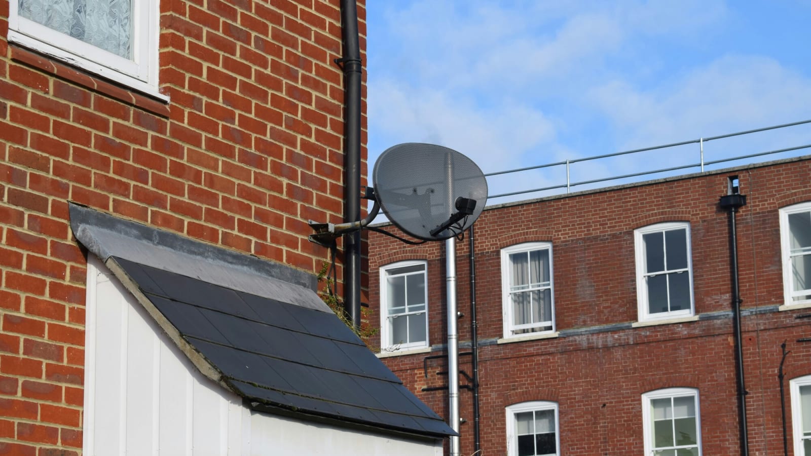 Satellite dish mounted to the side of a house